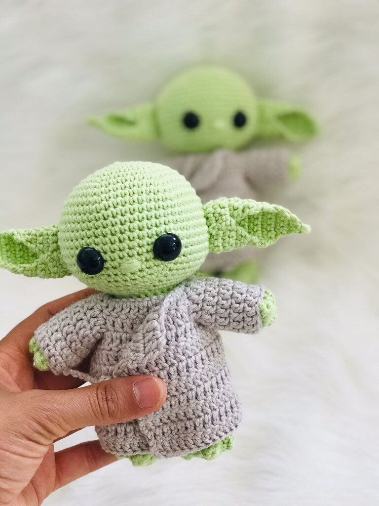 Hand-crocheted alien in a robe, a unique and imaginative decorative piece.