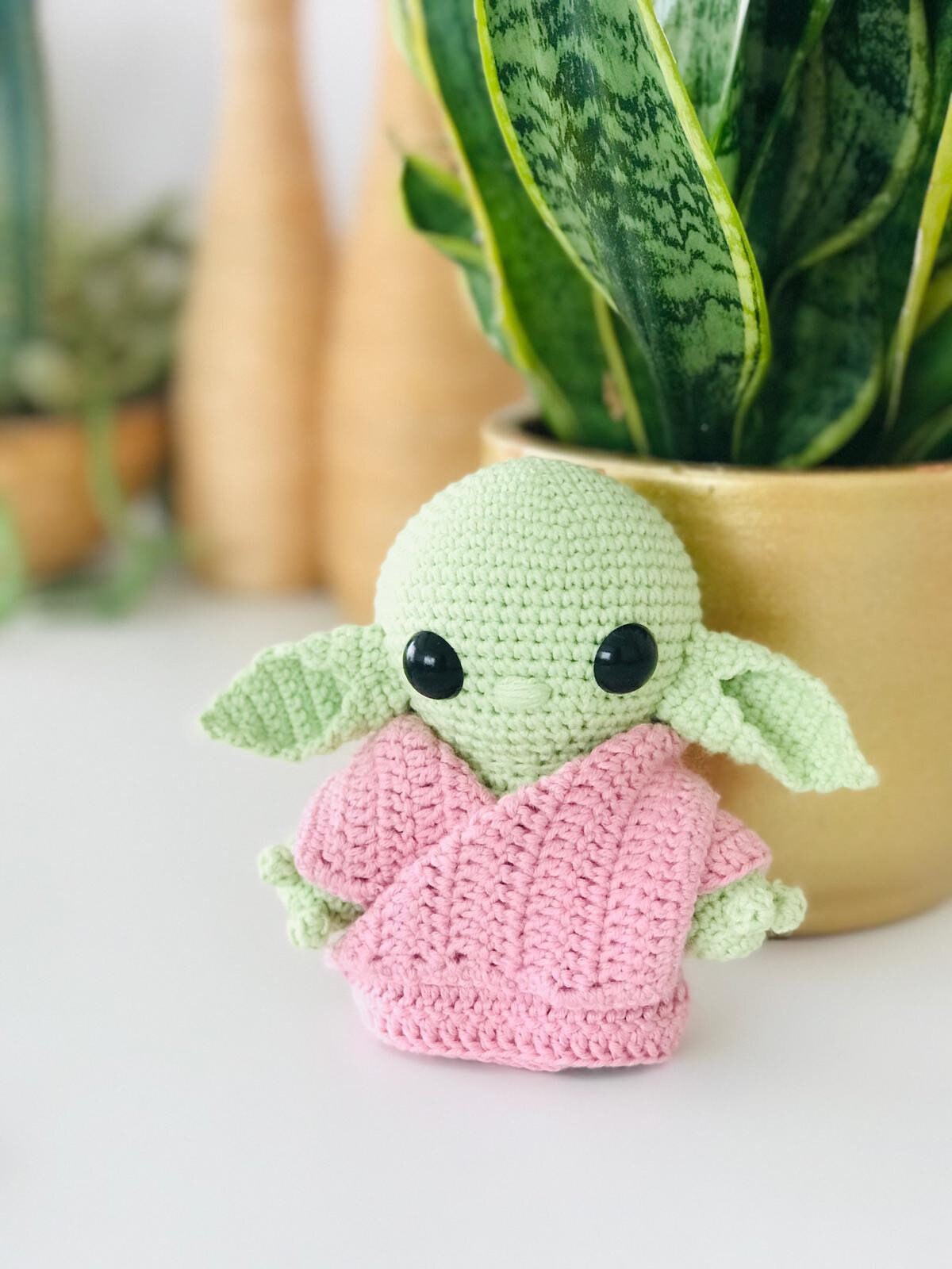 Customisable crochet alien figure wearing a blue jacket, a unique handmade toy.
