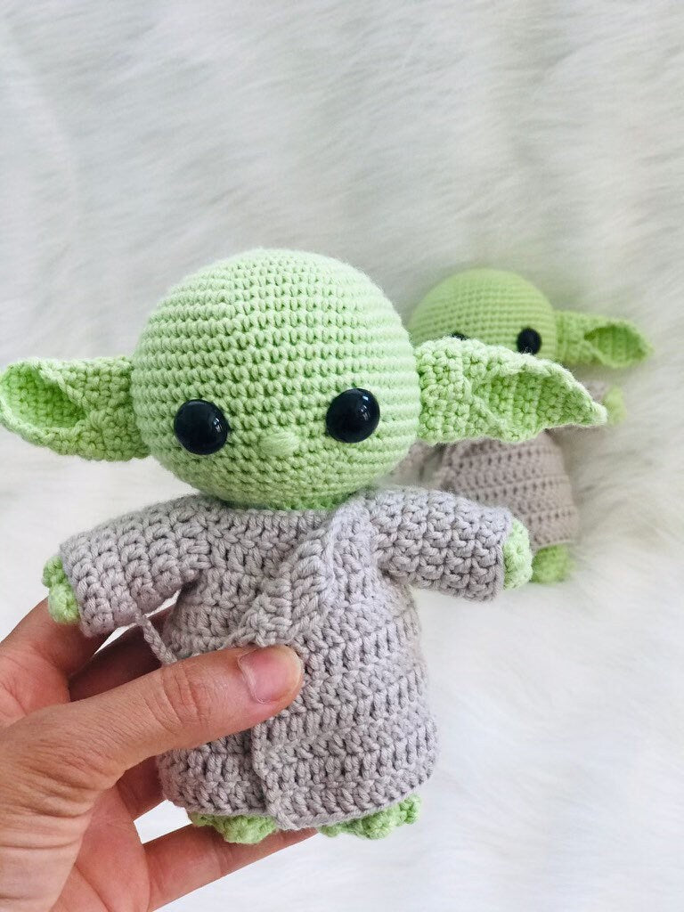 Hand-crocheted alien in a robe, a unique and imaginative decorative piece.