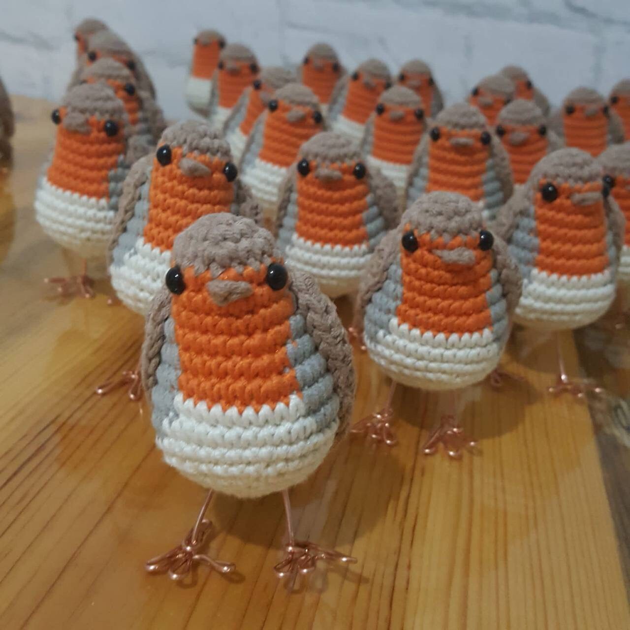 A charming handmade robin amigurumi plush toy with red and brown details.