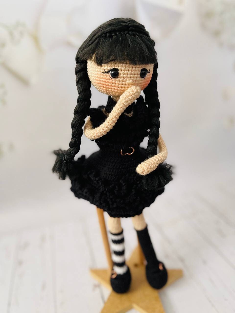 Hand-crocheted Wednesday Addams inspired doll wearing her black raven party dress