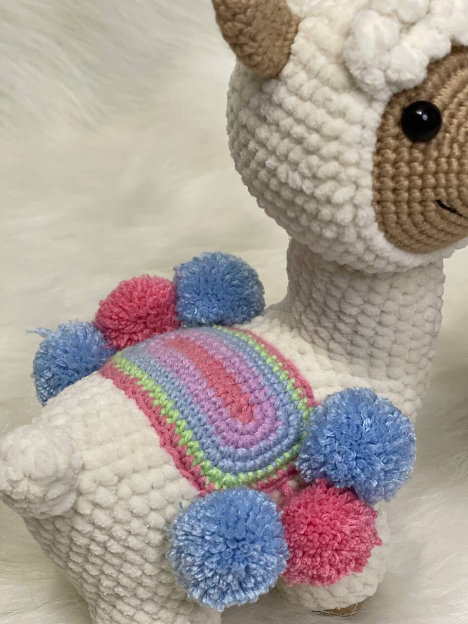 This charming crocheted alpaca comes in either a white or brown variant, both featuring soft colors that capture the gentle nature of the llama species. The adorable face and top knot pair wonderfully well with the posable legs and tail.
