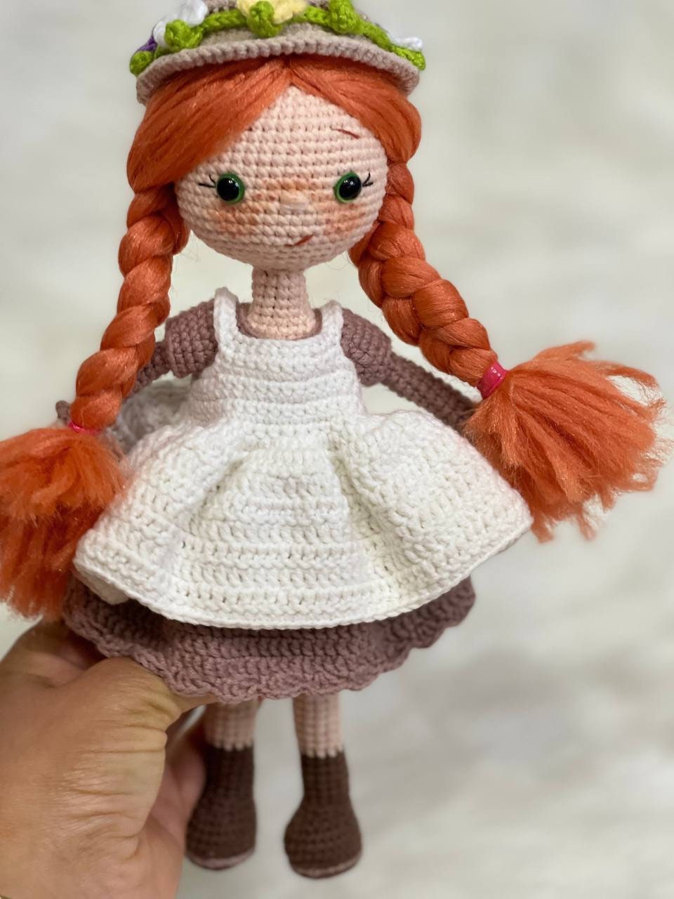 Crocheted Anne of Green Gables Doll with red hair, beige hat, and two dresses. Handmade with care to capture the essence of the beloved literary character. perfect for gifting to fans of the book series or anyone who loves dolls and handmade crafts.