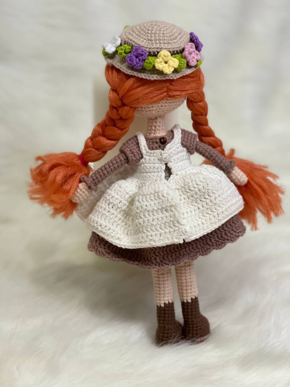 Crocheted Anne of Green Gables Doll with red hair, beige hat, and two dresses. Handmade with care to capture the essence of the beloved literary character. perfect for gifting to fans of the book series or anyone who loves dolls and handmade crafts.