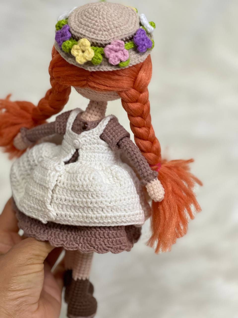 Crocheted Anne of Green Gables Doll with red hair, beige hat, and two dresses. Handmade with care to capture the essence of the beloved literary character. perfect for gifting to fans of the book series or anyone who loves dolls and handmade crafts.