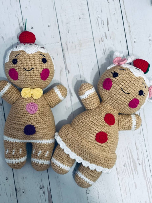 A pair of Crochet Gingerbread toys Mr and Mrs Gingerbread, with intricate detailing on their icing and fruit decorations. These soft and cuddly gingerbread toys are hand crocheted with chenille yarn and stand approximately 23-25 cm tall.