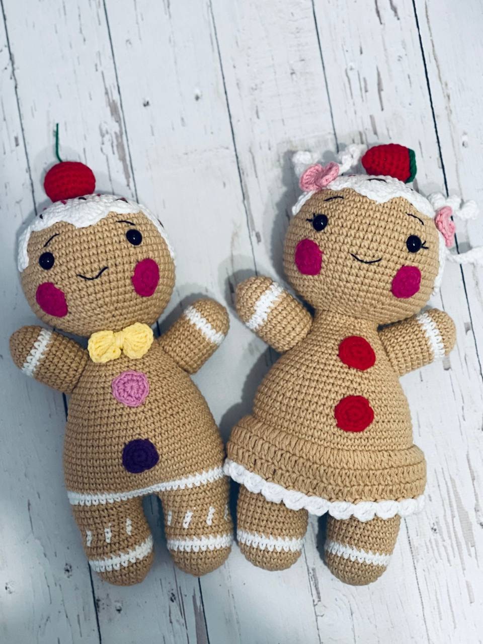 A pair of Crochet Gingerbread toys - Mr and Mrs Gingerbread, with intricate detailing on their icing and fruit decorations. These soft and cuddly gingerbread toys are hand crocheted with chenille yarn and stand approximately 23-25 cm tall.