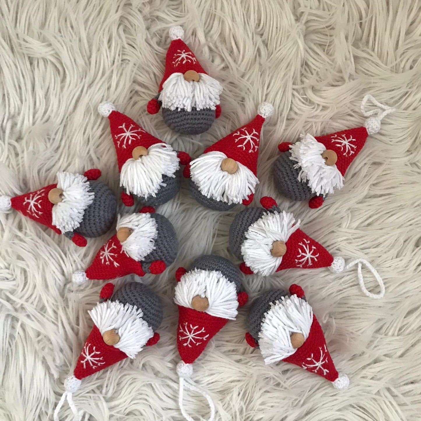 Handmade crochet Christmas decoration of a Scandinavian gnome, also known as a Gonk, with a red and white striped hat and a fluffy white beard. Perfect for adding a cozy and festive touch to your holiday decor. Made with love by a skilled artisan