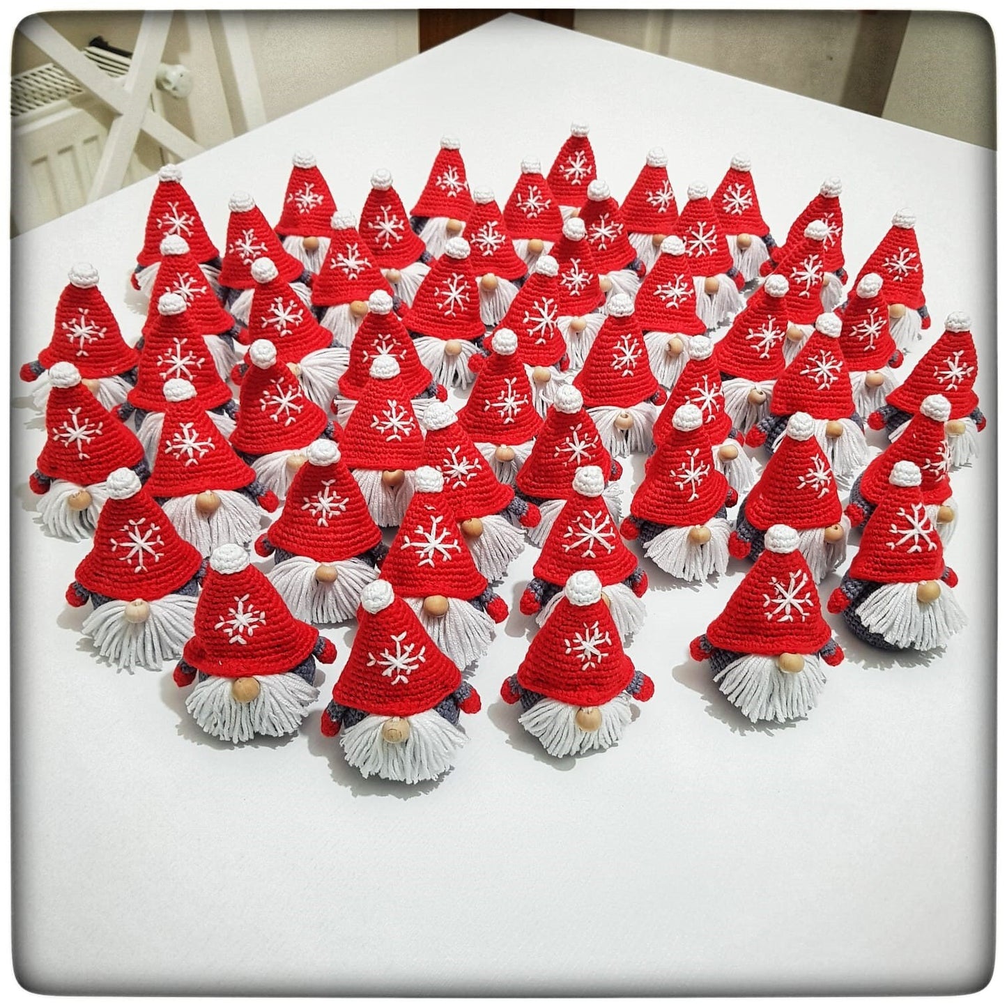 Handmade crochet Christmas decoration of a Scandinavian gnome, also known as a Gonk, with a red and white striped hat and a fluffy white beard. Perfect for adding a cozy and festive touch to your holiday decor. Made with love by a skilled artisan