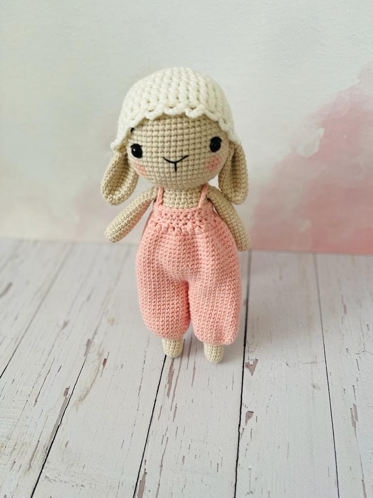 Hand crocheted cute bunny with a hanging pant made of pastel colors. The bunny is made of soft yarn and measures approximately 20cm in height Its hanging pant has beautiful stripes This adorable bunny is a great gift for anyone who loves cute animals