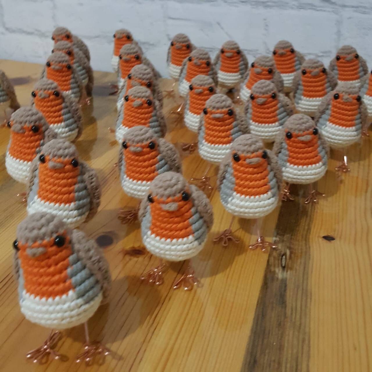 lose-up of a crochet red robin showing its intricate stitching and copper wire feet.