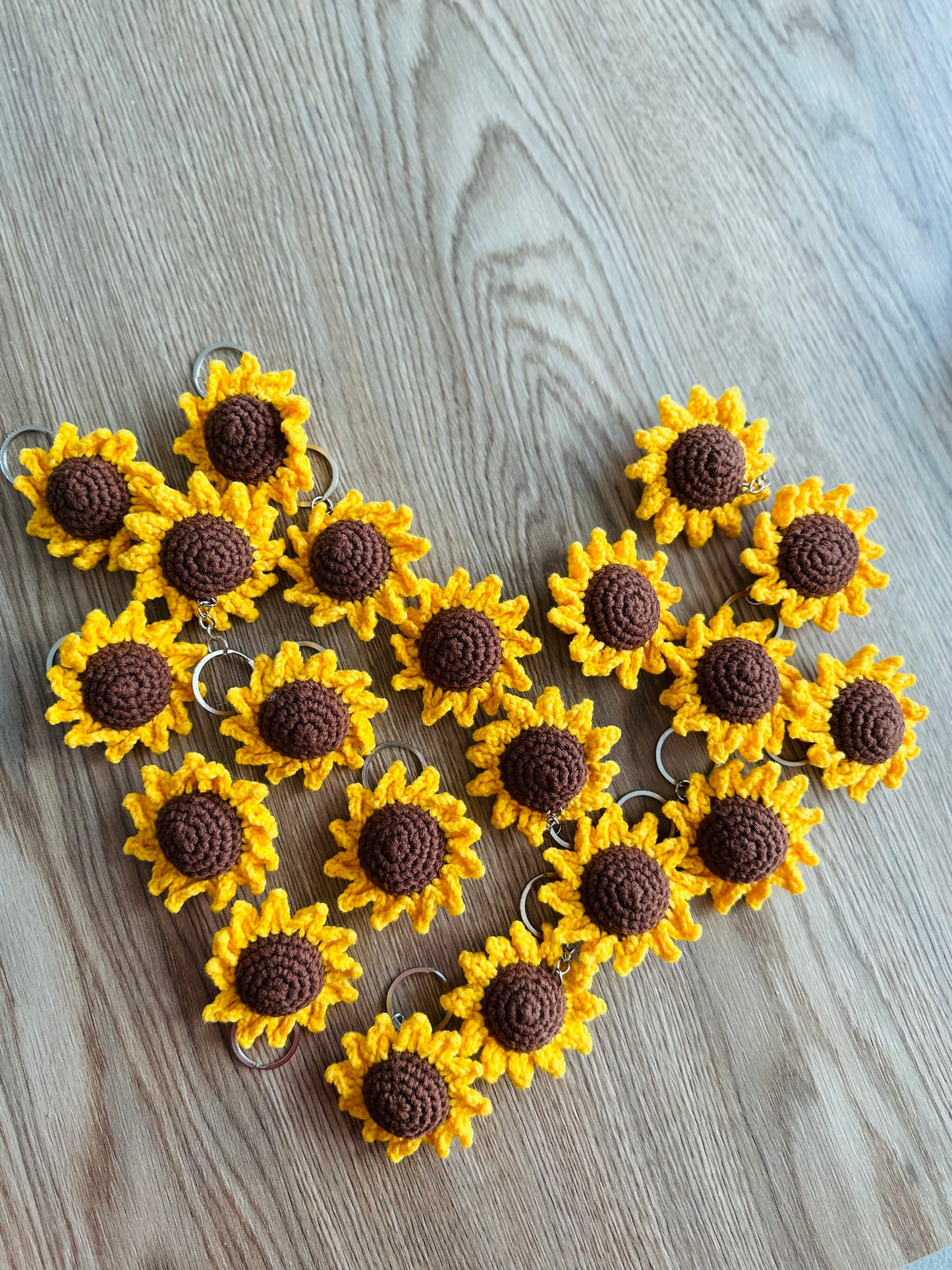 A cheerful yellow and brown crochet sunflower keyring, perfect for adding a touch of handmade charm to your keys.