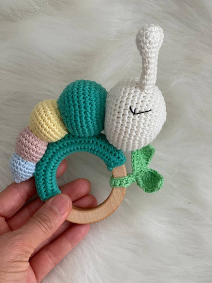Hand-knit caterpillar teether attached to a safe wooden ring for infants