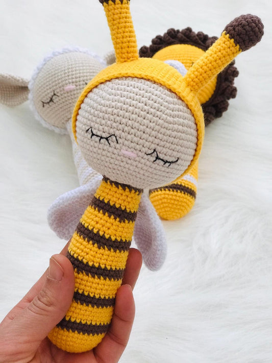 Handmade crochet bee rattle with black and yellow stripes and a gentle bell inside.
