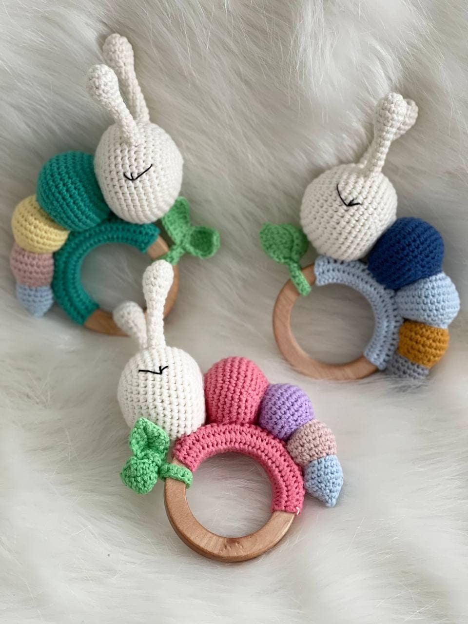 Colorful organic crochet baby rattle in the shape of a caterpillar with antennae