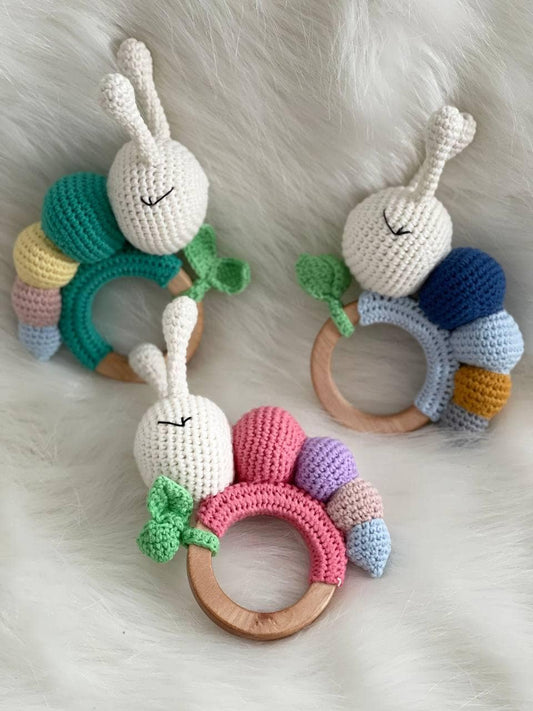 Colorful organic crochet baby rattle in the shape of a caterpillar with antennae