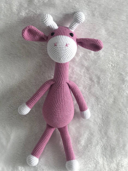 This is an instantly eye-catching a crocheted pink giraffe with a white horn! The giraffe appears to have been made from soft, colorful yarn that&#39;s been cleverly shaped and manipulated by skilled hands into its gentle curves.