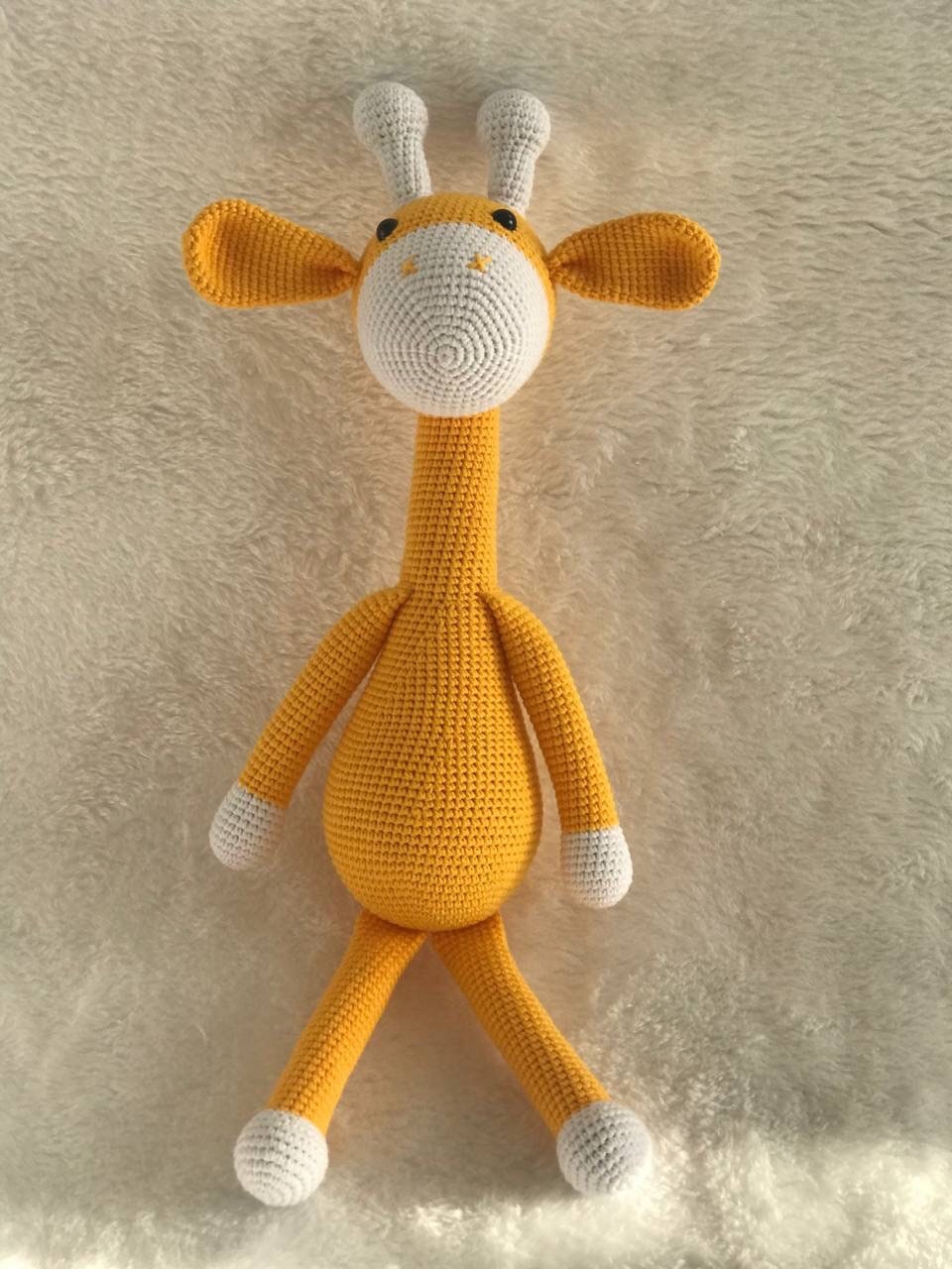 This is an instantly eye-catching a crocheted gold yellow giraffe with a white horn! The giraffe appears to have been made from soft, colorful yarn that&#39;s been cleverly shaped and manipulated by skilled hands into its gentle curves.