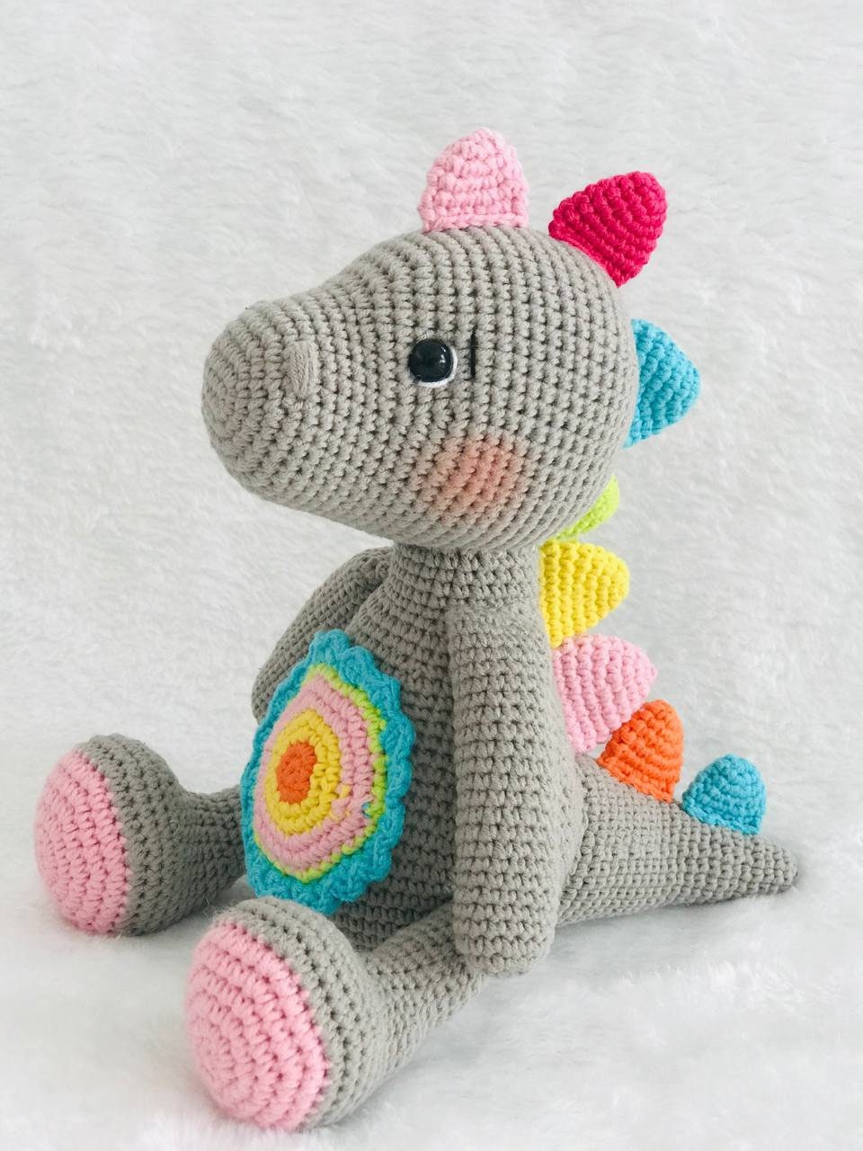 Handmade crochet baby dinosaur toy with soft yarn and embroidered features Cute and cuddly crochet baby dinosaur with embroidered details Small handmade crochet dinosaur toy for babies and toddlers Adorable crochet dinosaur with embroidered eyes