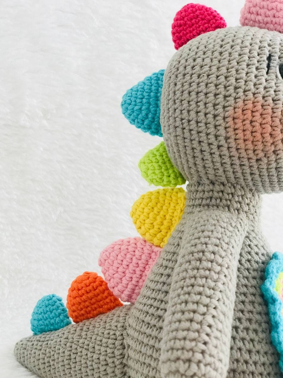 Handmade crochet baby dinosaur toy with soft yarn and embroidered features Cute and cuddly crochet baby dinosaur with embroidered details Small handmade crochet dinosaur toy for babies and toddlers Adorable crochet dinosaur with embroidered eyes