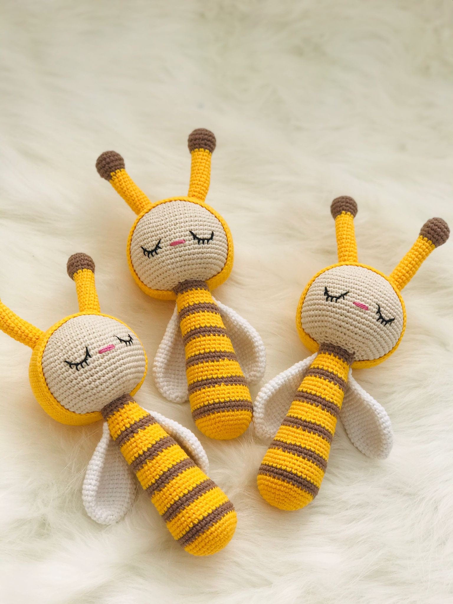 Handmade crochet bee rattle with black and yellow stripes and a gentle bell inside.
